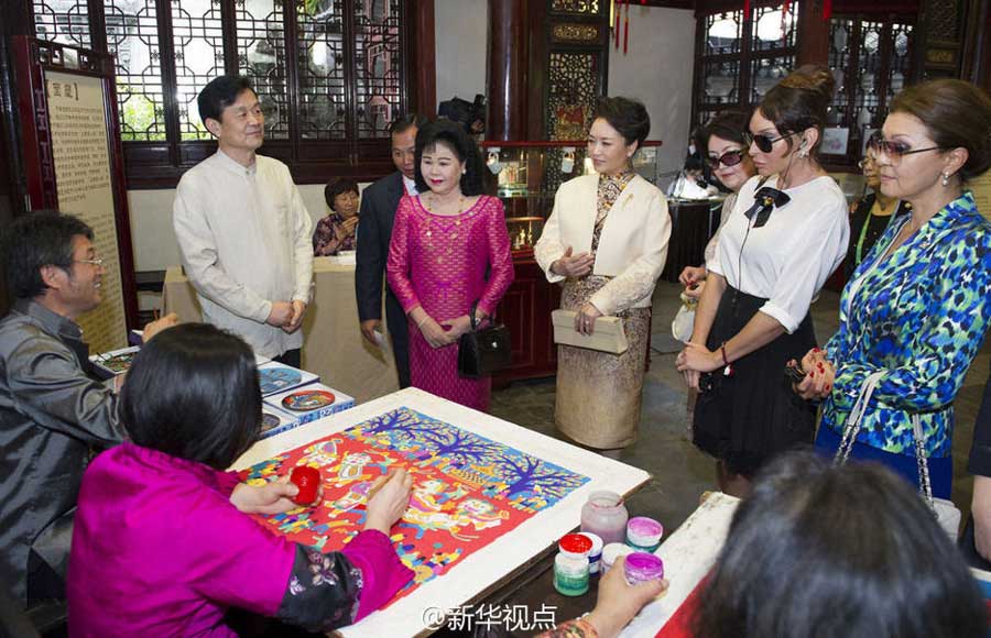 Chinese first lady Peng Liyuan and her counterparts enjoy China's traditional arts and culture in the centuries-old Yuyuan Garden on Wednesday.[Photo/Xinhua]
