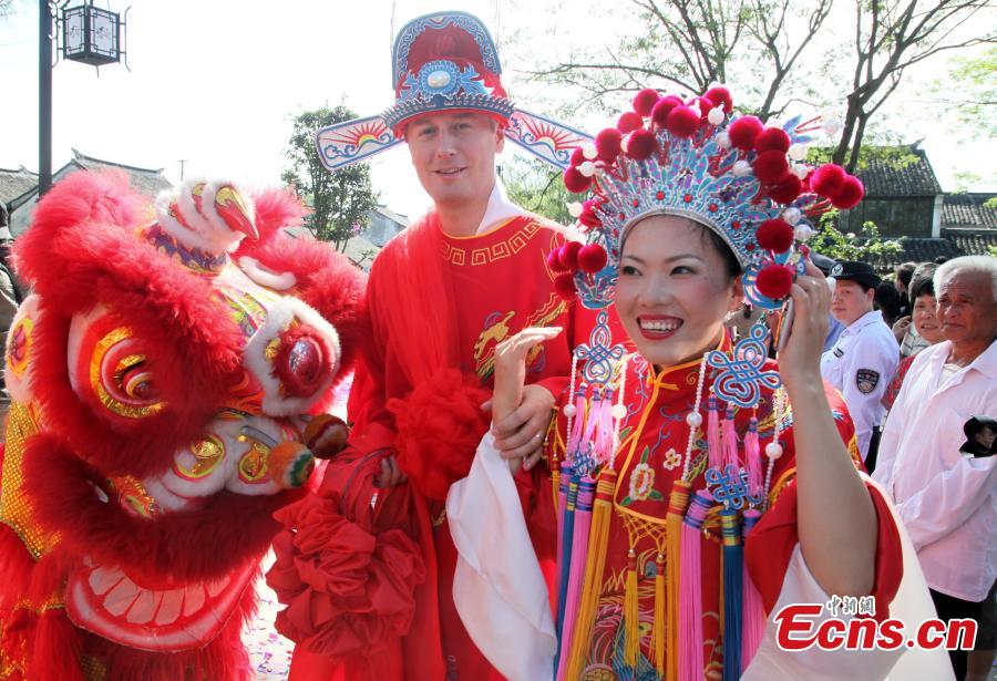 A traditional Chinese wedding ceremony for 20 foreign couples is held in Fengjing, an ancient water town of Shanghai on Sunday, September 21, 2014. Couples from 14 countries including India, Singapore, Afghanistan, Spain, and Poland tied the knot and experienced local ethnic customs at the event. 