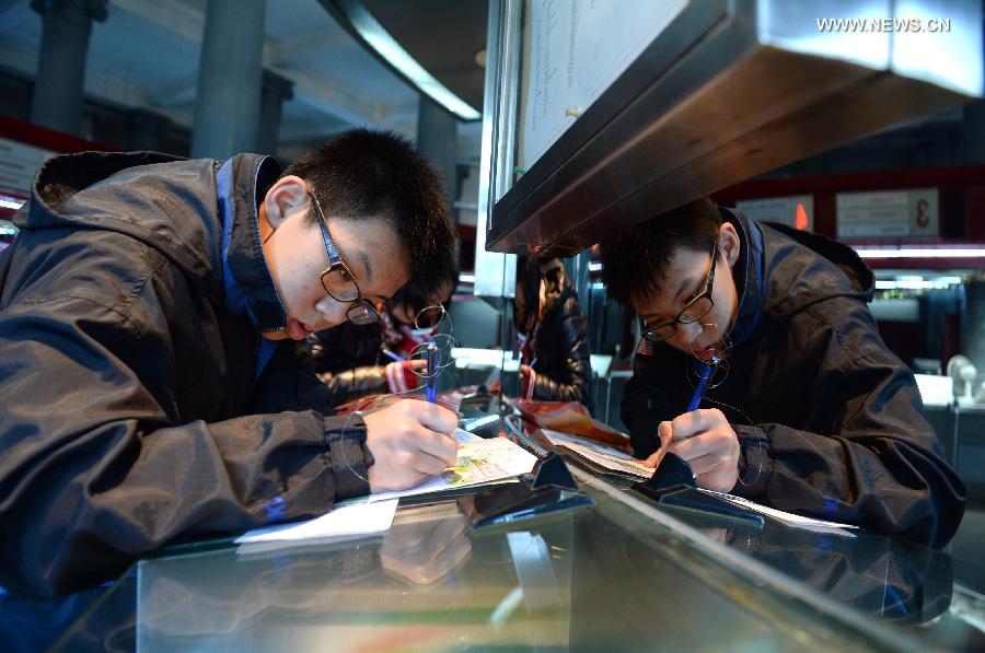 A junior high school student mails to his family at a post office in Macao, south China, Dec. 20, 2014. The Macao Post issued souvenir stamp folders and two sets of philatelic items to mark the 15th anniversary of the establishment of the Macao Special Administrative Region (SAR) on Saturday. (Xinhua/Qin Qing)