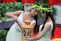 Girls in white dresses pass down the torch for Tomb Sweeping Day