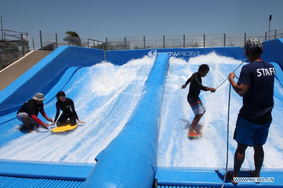 People learn surfing at water park where manmade waves provided in