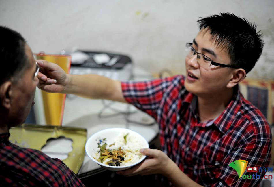 Shen Hai, a junior student of Huainan Normal University in Anhui Province, feeds his father suffering from hemiplegia on July 16, 2015. (Photo/youth.cn)
