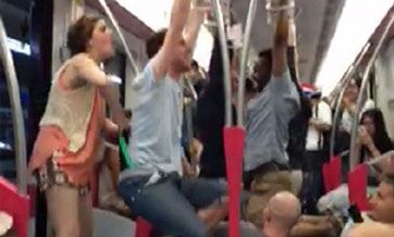 Foreign passengers swing on handrails in Shanghai metro