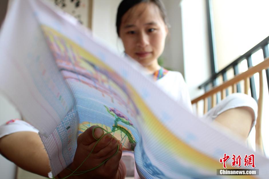 Armless girl does cross-stitch embroidery with her feet