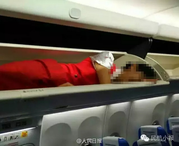 Air stewardesses packed into overhead bin