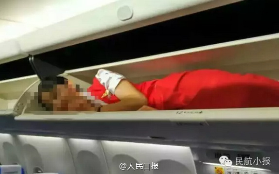Air stewardesses packed into overhead bin