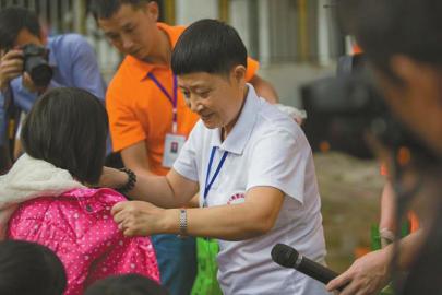 Wu Yongxiu donates clothes to the children in remote area. (Photo/wccdaily)