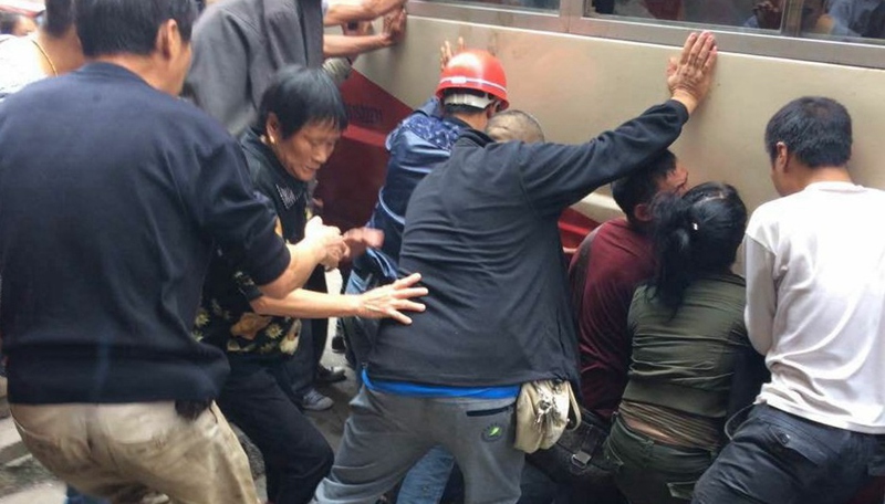 Passers-by lift bus to save elderly under wheels