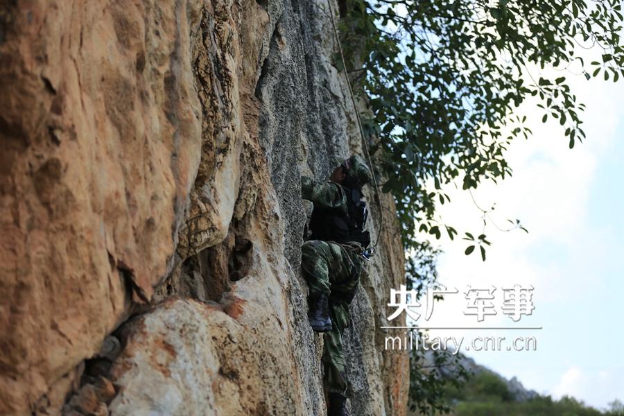 Female soldier of armed police force climbs cliff barehanded