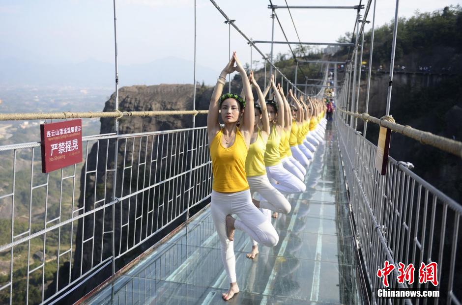 100 people perform yoga on 180-meter-high glass bridge 