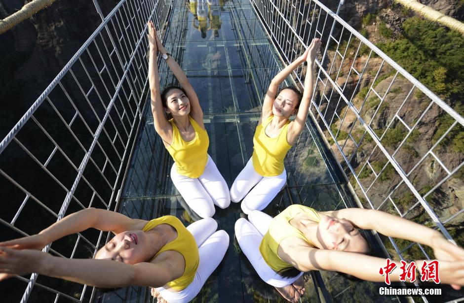 100 people perform yoga on 180-meter-high glass bridge 