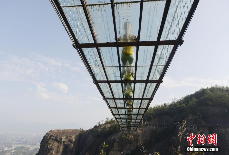 100 people perform yoga on 180-meter-high glass bridge 
