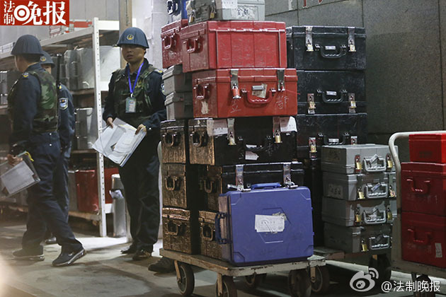 43 armored cash-in-transit vans wait in line to transport new 100-yuan banknotes