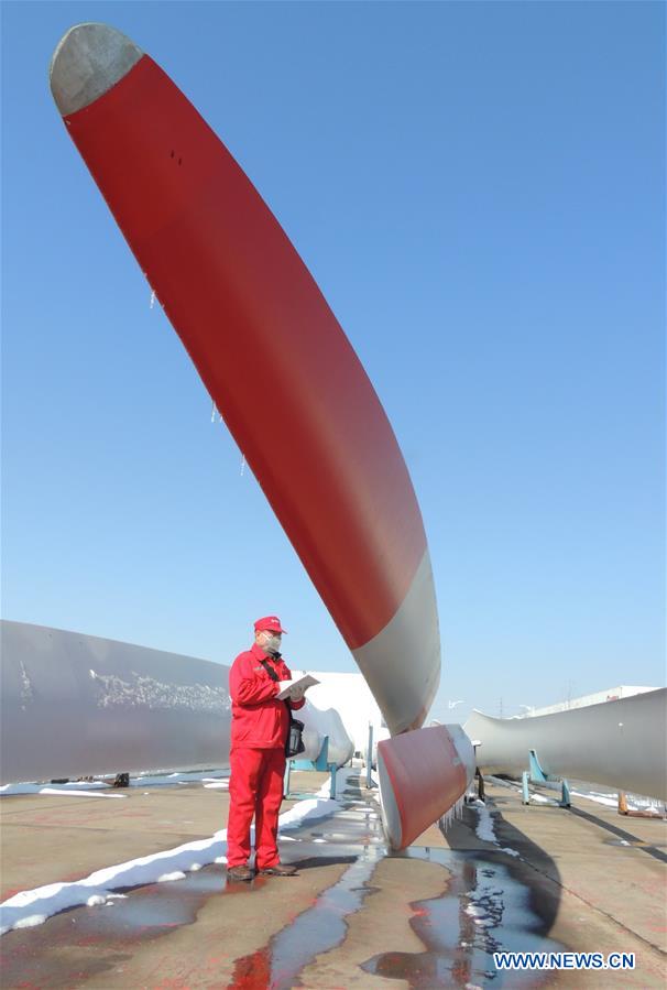 Quality control personnels examine wind-power blades in E China
