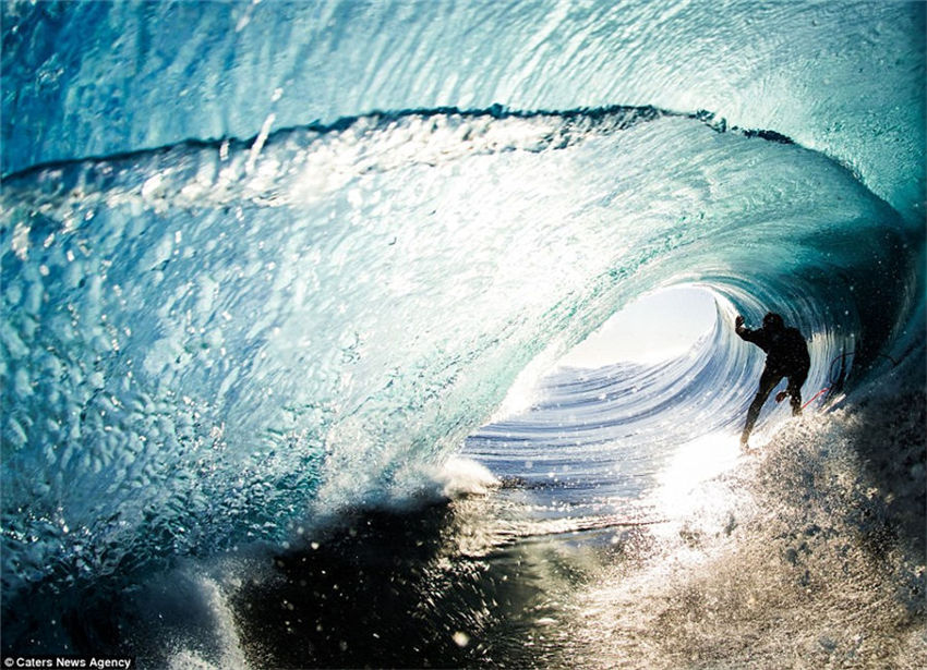 Teenager captures incredible photos of pro-surfers riding huge waves from inside the barrel as he tags along behind them
