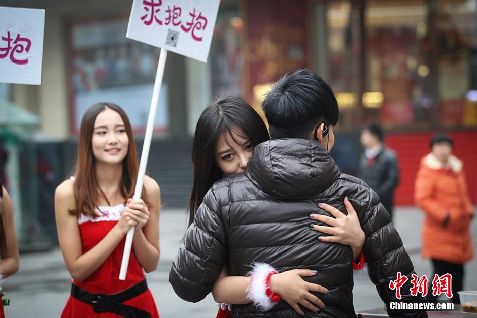 Women in Santa Claus red offer free hugs in downtown Nanjing