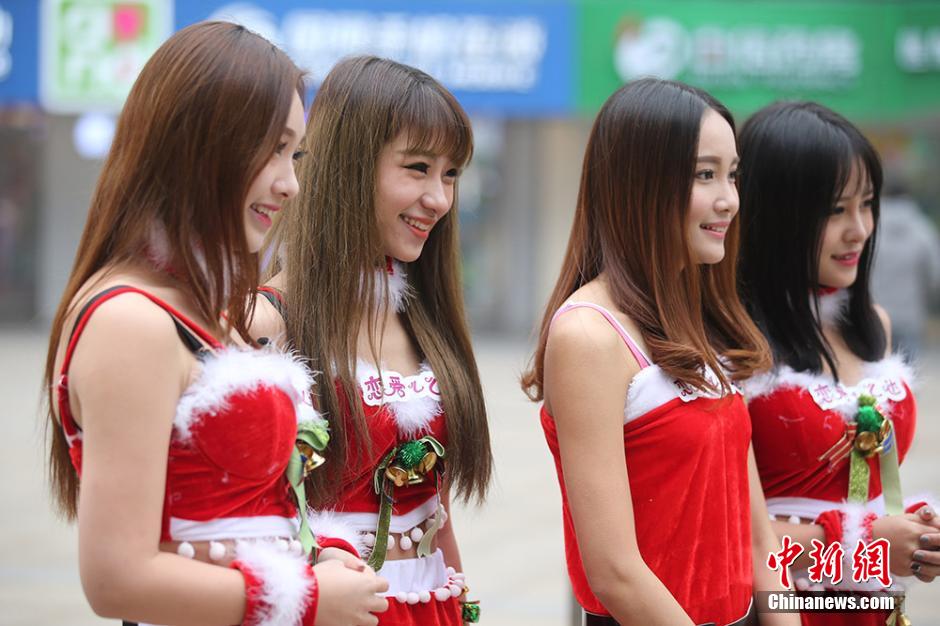 Women in Santa Claus red offer free hugs in downtown Nanjing