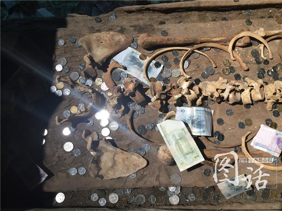 Human remains in museum covered by coins and banknotes thrown by tourists