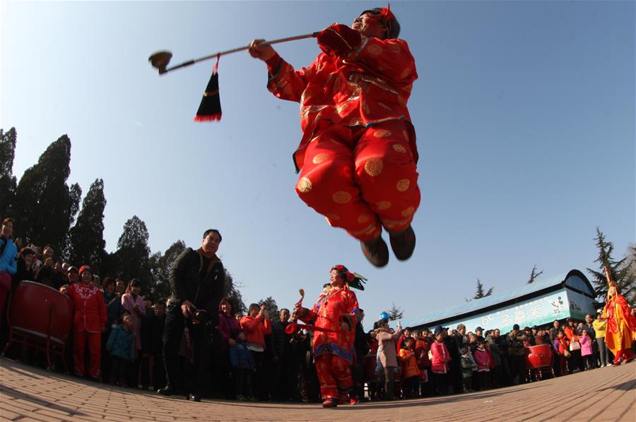 People view folk art performance in China's Yantai