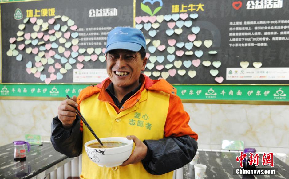 A cleaner exchanges a Post-it note for a bowl of beef noodles in a restaurant in Lanzhou, capital of Gansu province on Feb. 18, 2016. (CNS/Yang Yanmin)