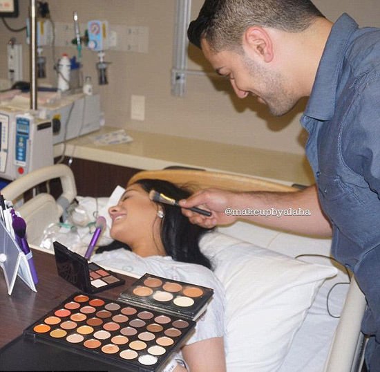 American woman puts on full face make-up in the middle of giving birth