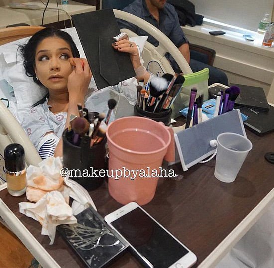American woman puts on full face make-up in the middle of giving birth