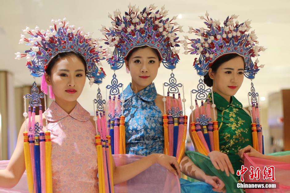 Models wearing phoenix coronet and cheongsam go down the runway