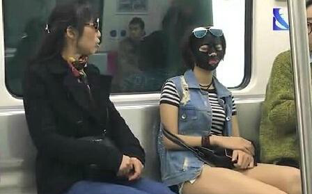 Woman rides subway wearing facial mask