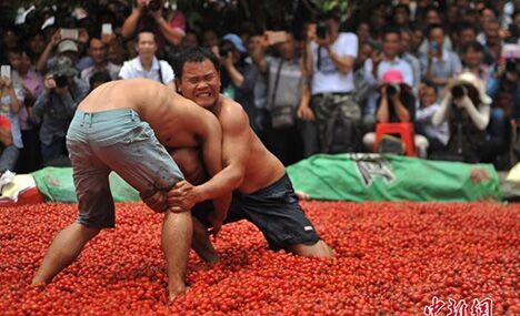 Zhuang people wrestle in pool of cherry tomatoes 