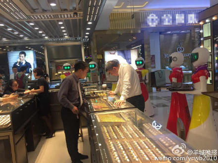 Eight female robots escort man shopping in gold store