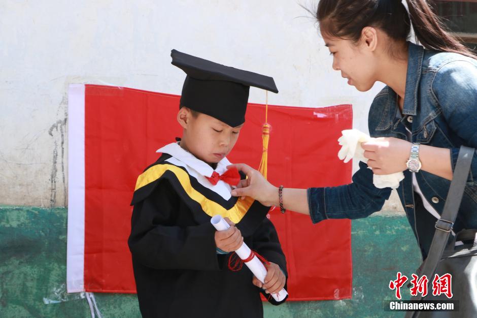 Volunteers take photos for left-behind children in bachelor gowns