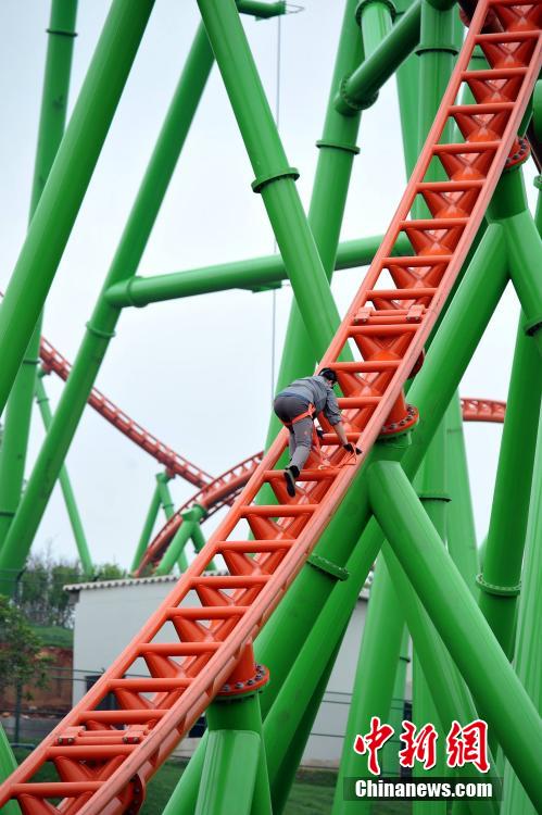 Man successfully climbs up 77-meter-high roller coaster