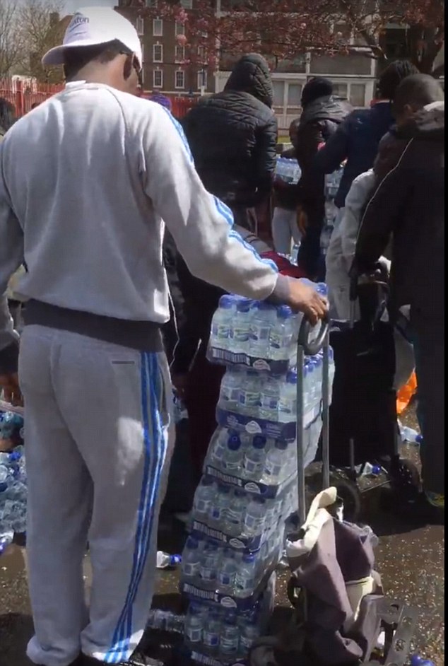 The London Loot-athon: Outrage as dozens of people are filmed brazenly snatching bottles of water left for marathon runners