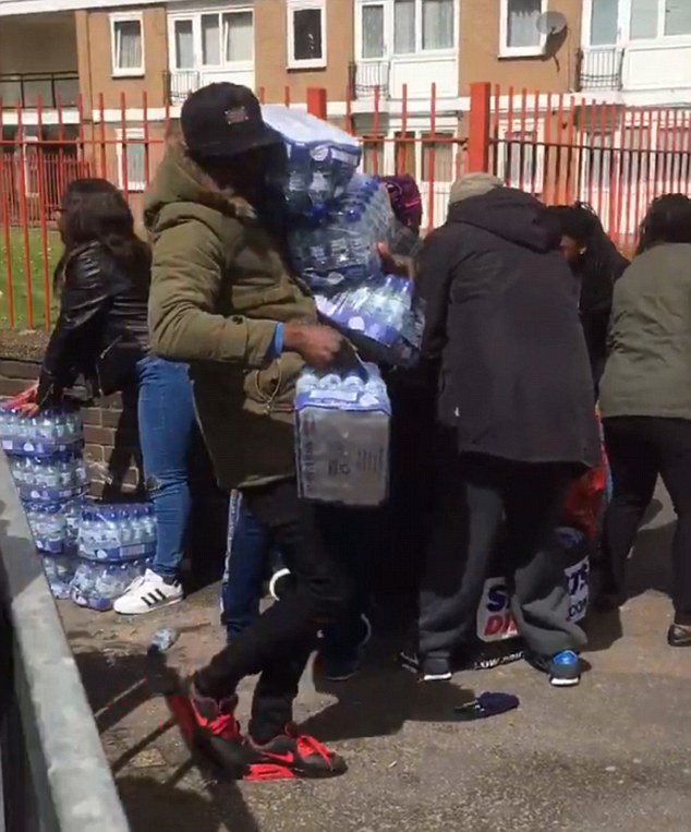The London Loot-athon: Outrage as dozens of people are filmed brazenly snatching bottles of water left for marathon runners