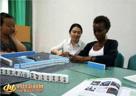 Students teach foreign teacher to play mahjong during class