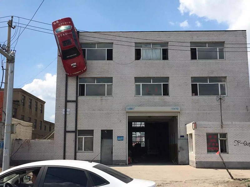 Man suspends car on outer wall of building