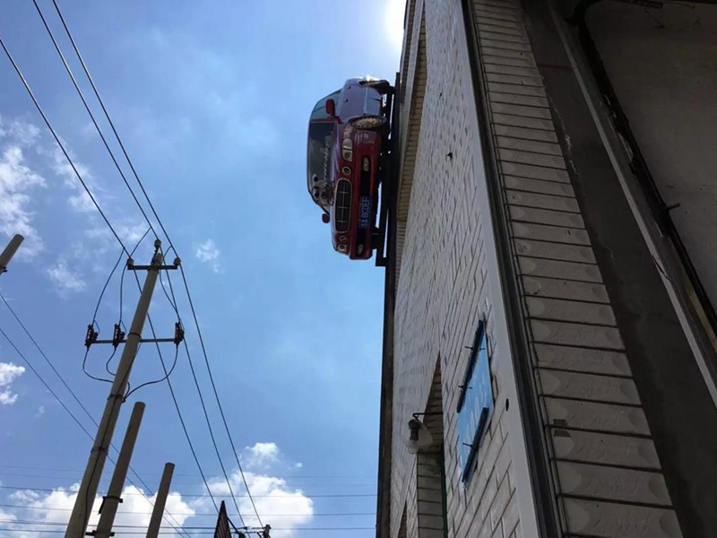 Man suspends car on outer wall of building