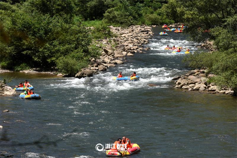 Tourists drift along river in Zhejiang scenic area