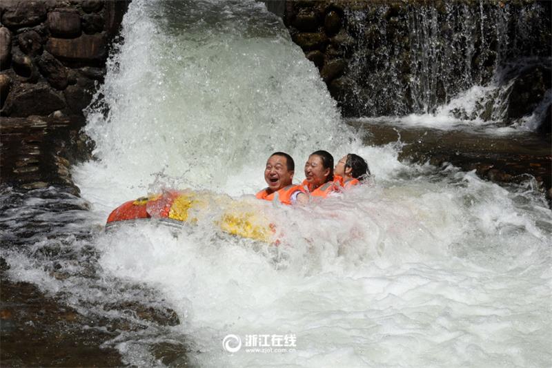 Tourists drift along river in Zhejiang scenic area