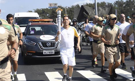 Ding Wuhao runs with Olympic torch during torch relay in Rio