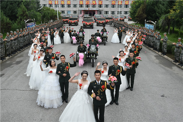 Couples exchanges 'bullet shell rings' at group wedding in military camp