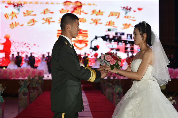 Couples exchanges 'bullet shell rings' at group wedding in military camp