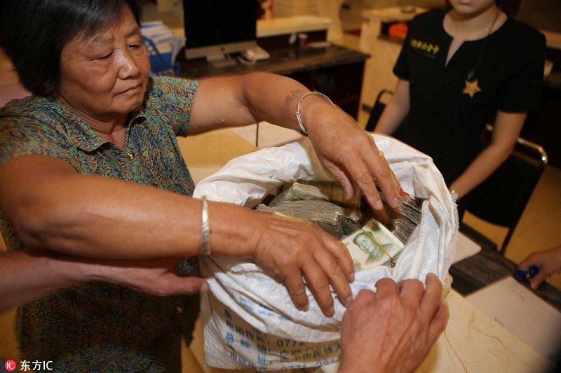 Elderly couple uses small bills to purchase property