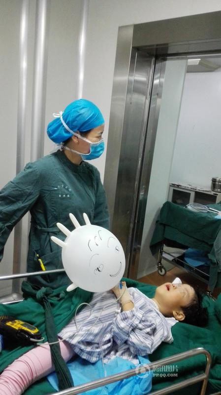 Nurse consoles young patient with 'balloon glove'