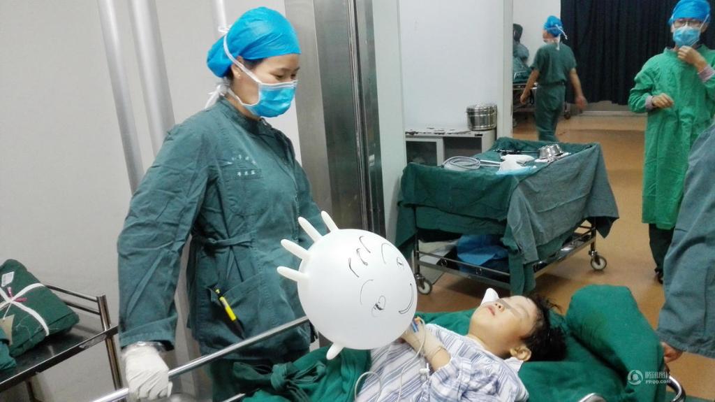Nurse consoles young patient with 'balloon glove'