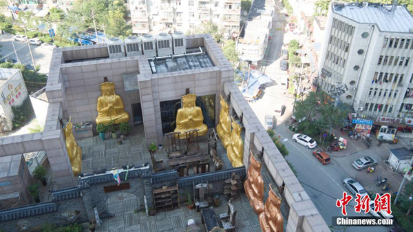 Gilded Buddha statues on building roof demolished