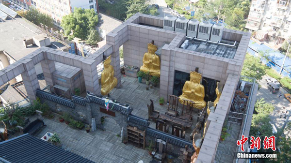 Gilded Buddha statues on building roof demolished