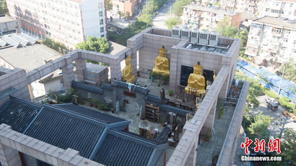 Gilded Buddha statues on building roof demolished