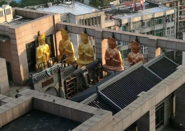 Gilded Buddha statues on building roof demolished