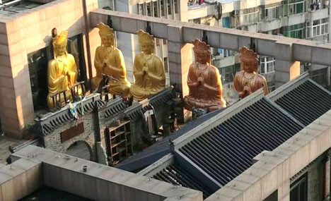 Gilded Buddha statues on building roof demolished